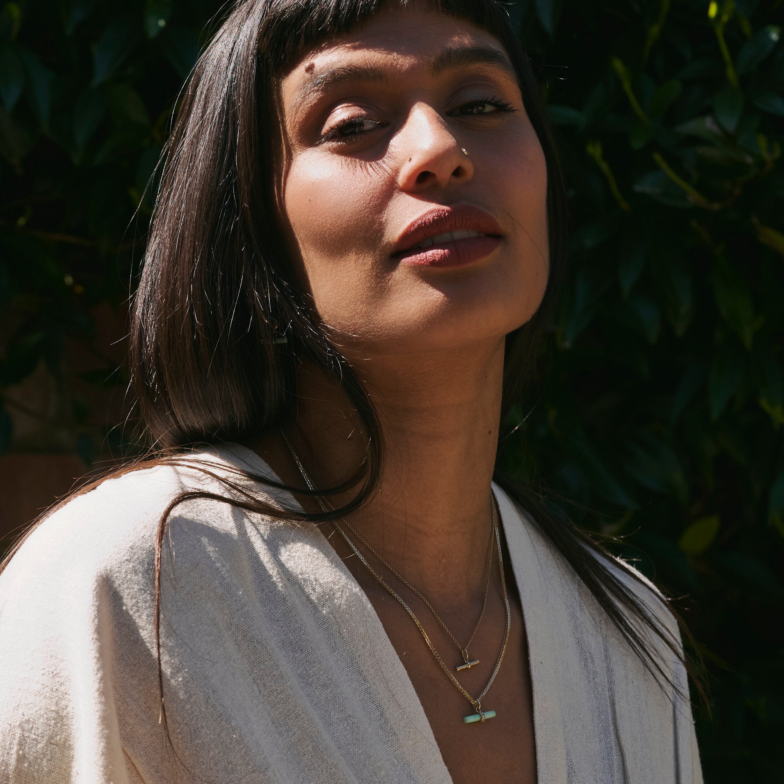 model wearing layered solid gold pendants including the Chrysoprase T-Bar Pendant 9k Gold