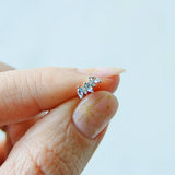 model hand holding the aquamarine & diamond flat back earring 14k gold