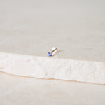 Mini Tanzanite Solitaire Flat Back Earring 14k White Gold on marble surface