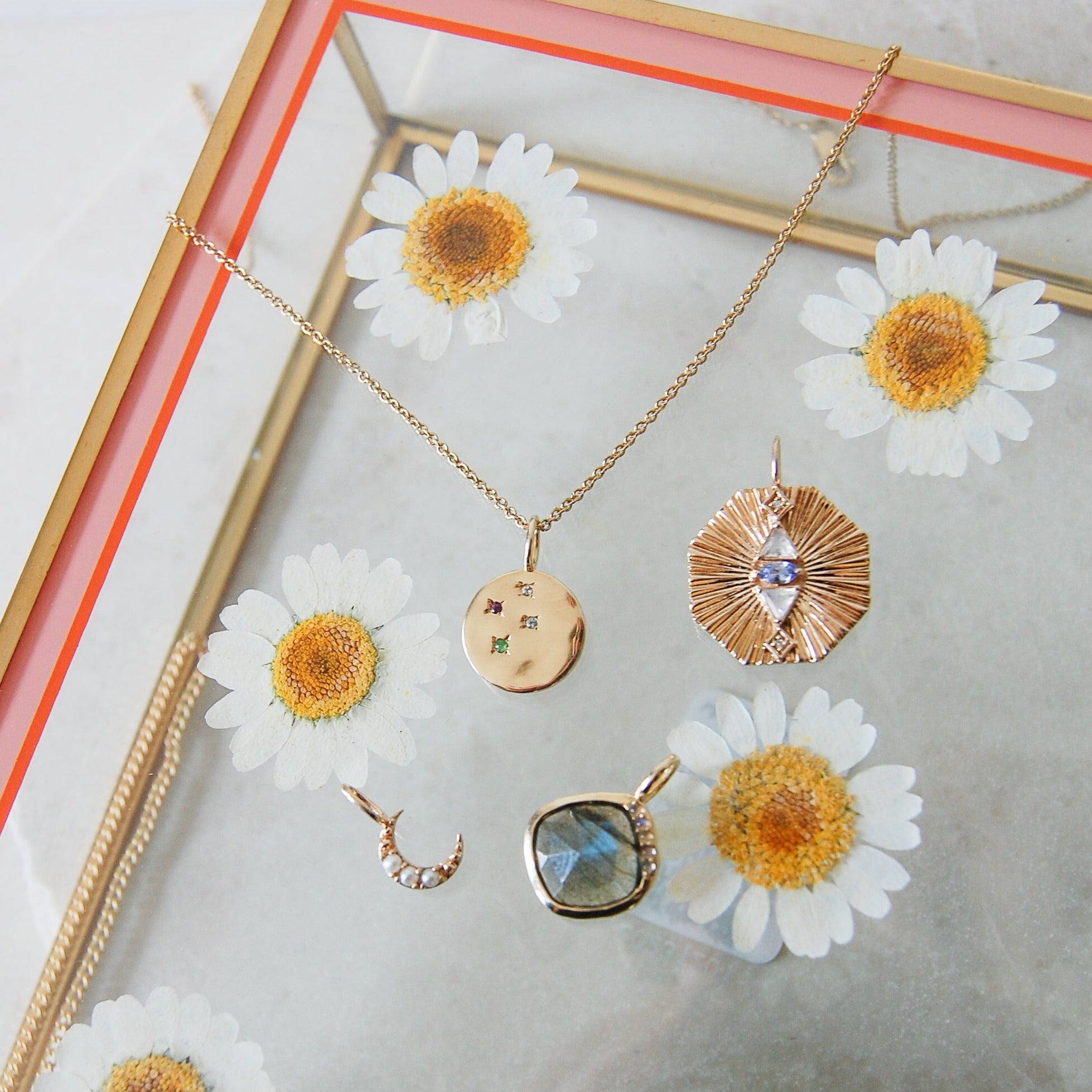 gold pendants in glass tray including the Multi Semi-Precious Organic Coin Pendant 9k Gold