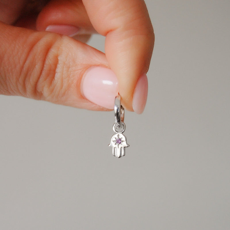 model hand holding the hand of fatima amethyst earring hoop in silver