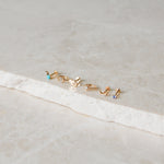 gold earring display on marble surface including the Turquoise & Diamond Flat Back Earring 9k Gold