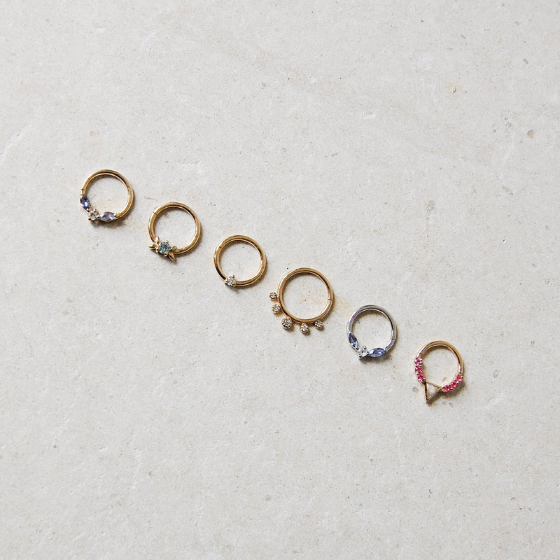 A collection of 6 daith earrings including one 9 karat gold hoop with tanzanite & moonstone