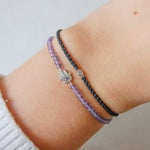 model wrist showing hand of fatima amethyst beaded bracelet in sterling silver and  diamond friendship bracelet in silver