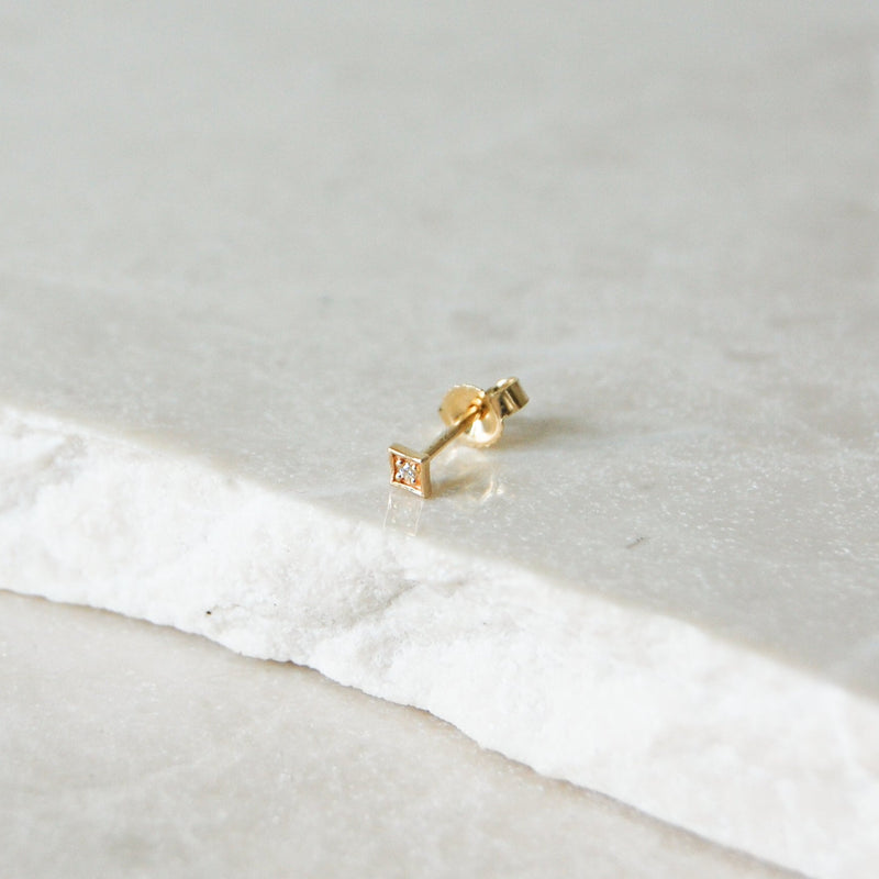 Diamond Star Stud Earring 9k Gold on marble surface