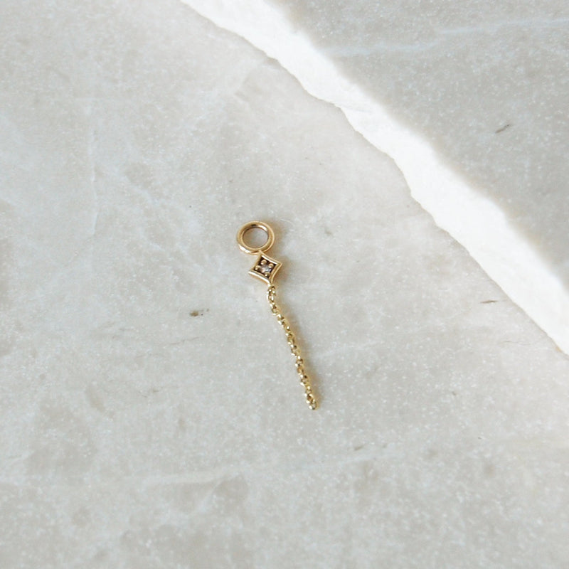 Diamond Star Chain Charm Earring 9k Gold on marble surface