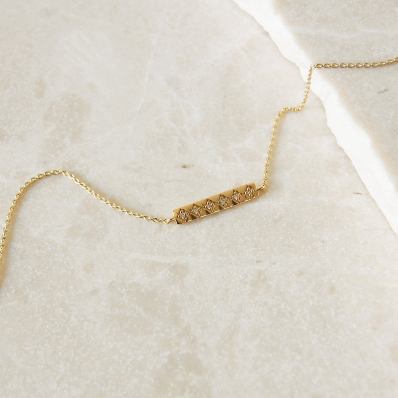 Diamond Bar Necklace 9k Gold on marble surface