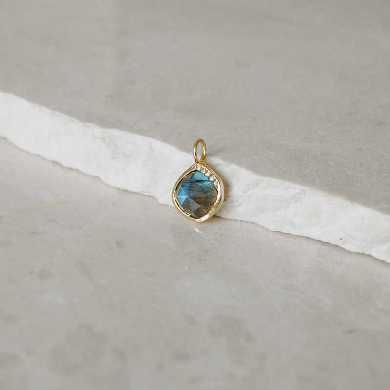 Grecian Labradorite Stone Pendant 9k Gold on marble surface