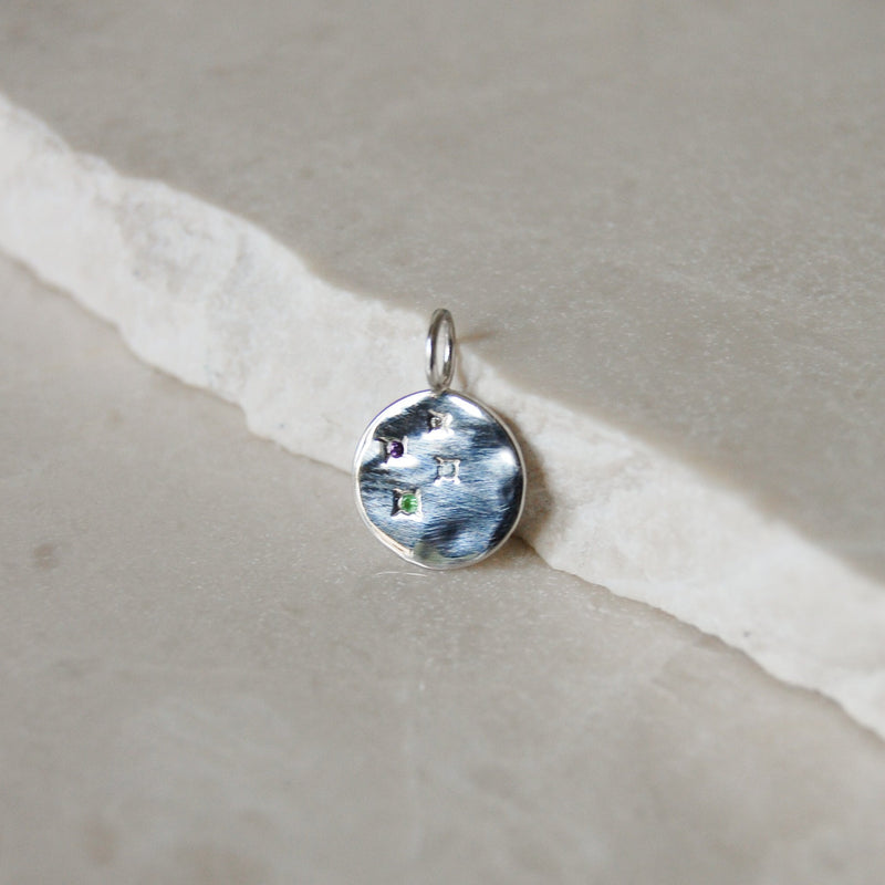 Multi Semi-Precious Organic Coin Pendant Sterling Silver resting on marble surface
