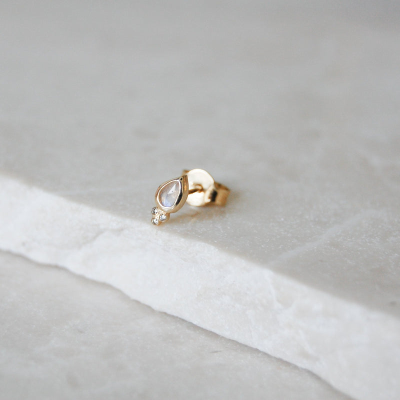 Moonstone & Diamond Tear Drop Stud Earring 9k Gold on marble surface