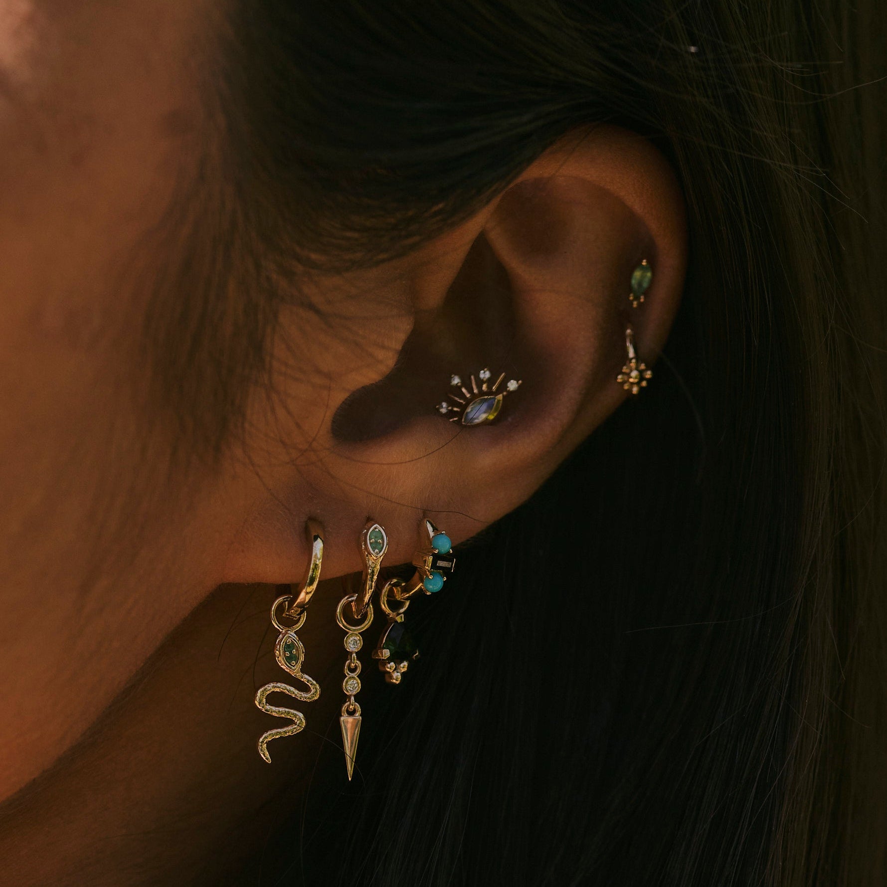 model wearing solid gold earrings and charms including the Diamond Drop Spike Earring Charm 9k Gold