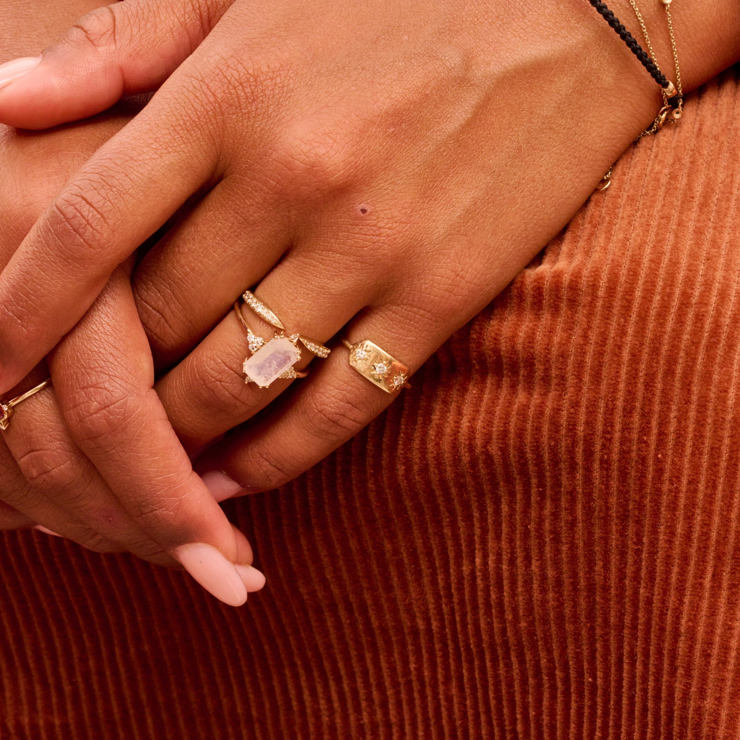 close up of model hand showing solid gold rings including the Diamond Starburst Ring 9k Gold
