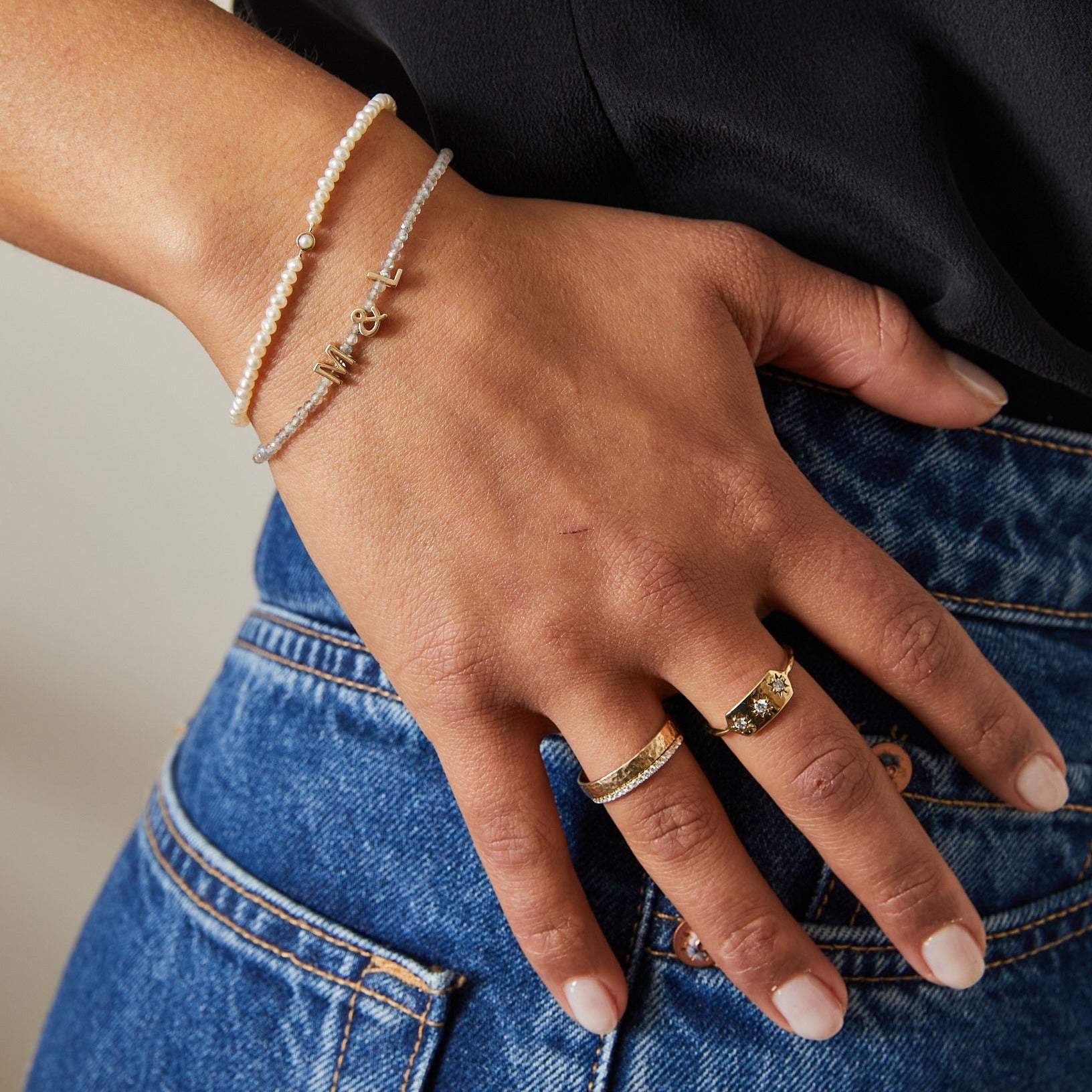 model hand and wrist showing solid gold rings and bracelets including the Diamond Starburst Ring 9k Gold
