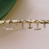 solid gold earring charms and huggies displayed on plant branch including the Diamond Starry Night Horn Earring Charm 9k Gold
