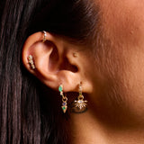 model ear stack close up showing solid gold earrings including the Emerald & Diamond Marquise Huggie Hoop 9k Gold