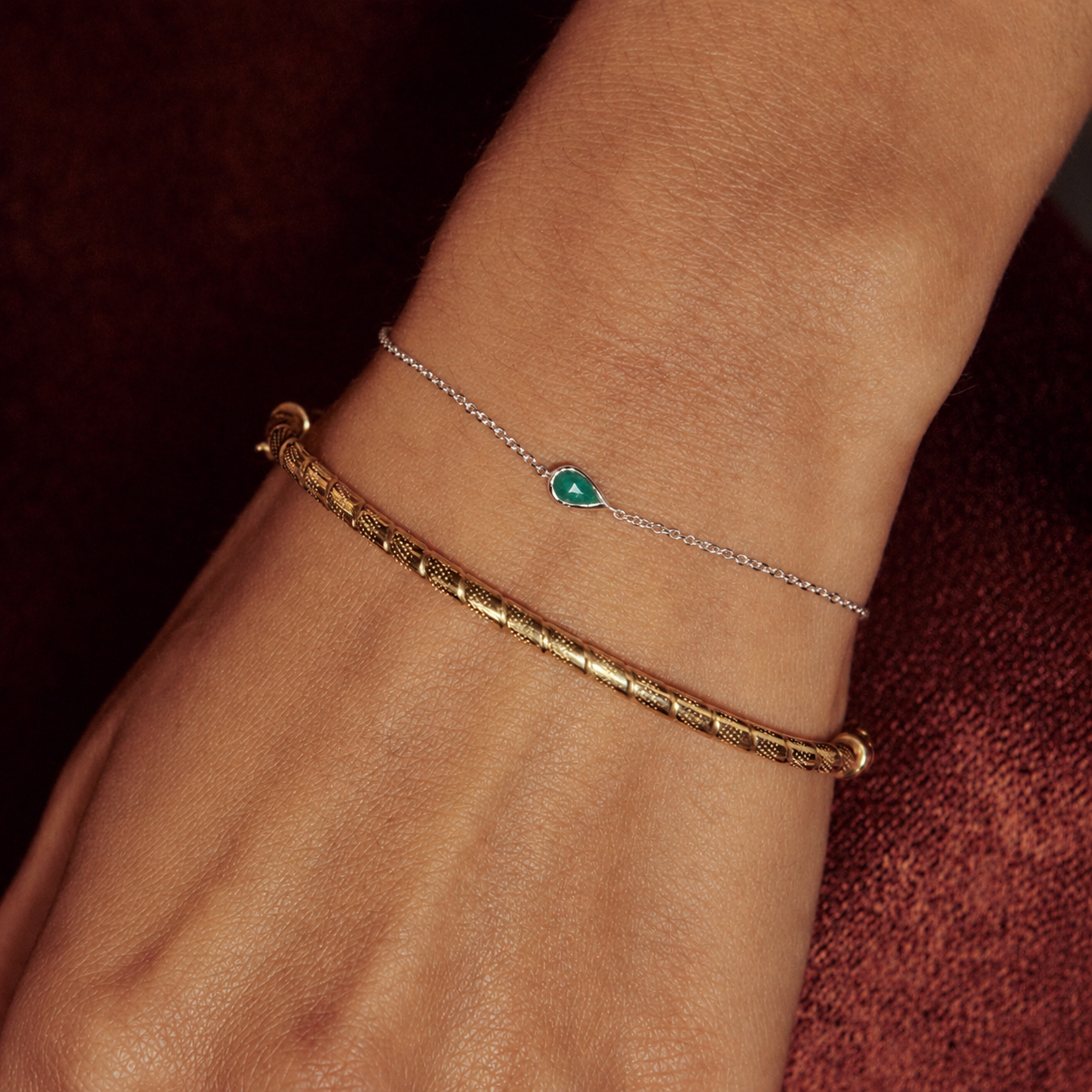 model wearing solid gold bangle and Emerald Raindrop Bracelet Sterling Silver