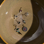 Collection of pendants on a ceramic plate with a neutral background