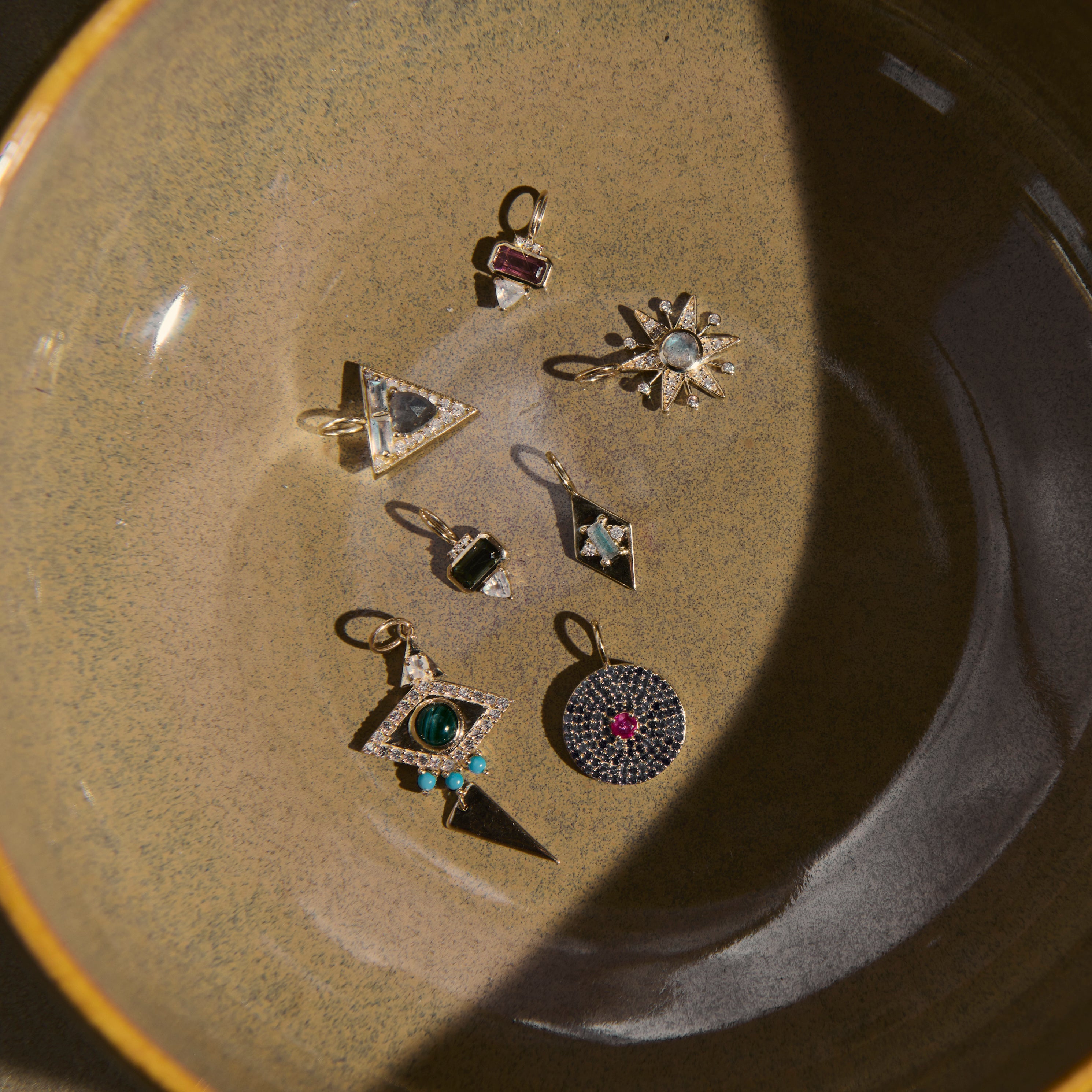 Collection of pendants on a ceramic plate with a neutral background