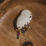 Close-up of a wooden jewelry box with a ring and earrings inside.