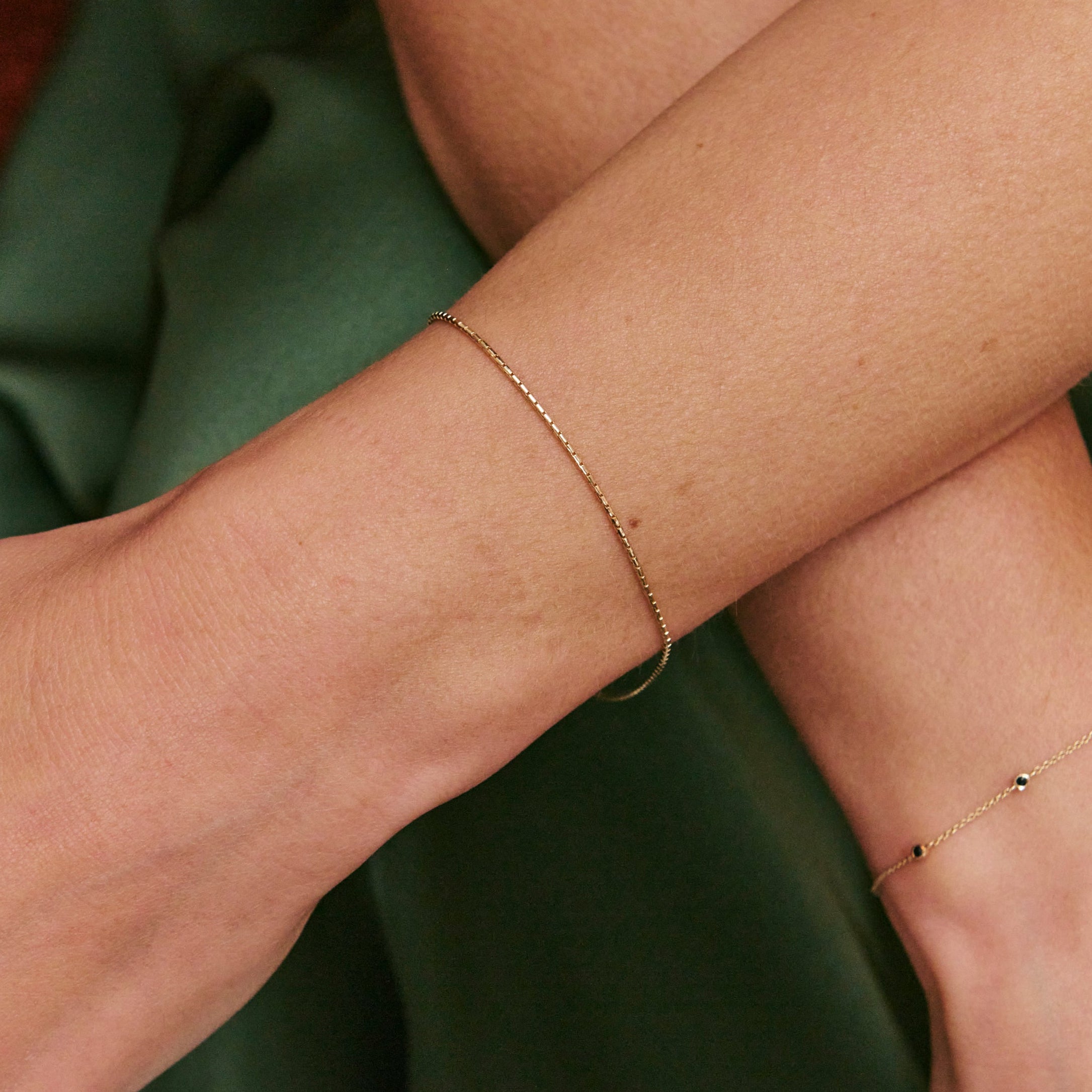 gold bracelet on model wearing green dress