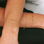 gold chain bracelets on model wearing black