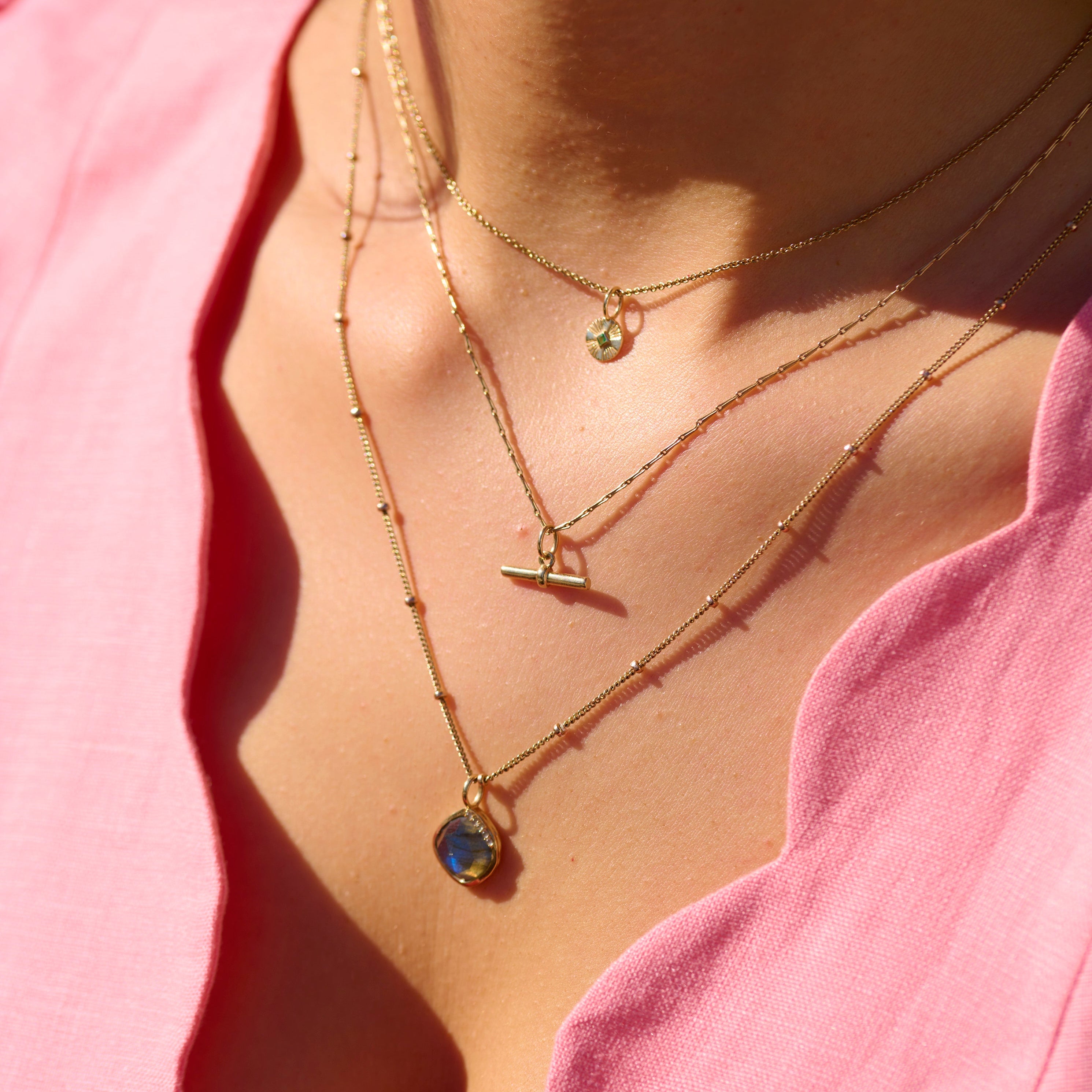 model wearing layered solid gold necklaces including the Grecian Labradorite Stone Pendant 9k Gold
