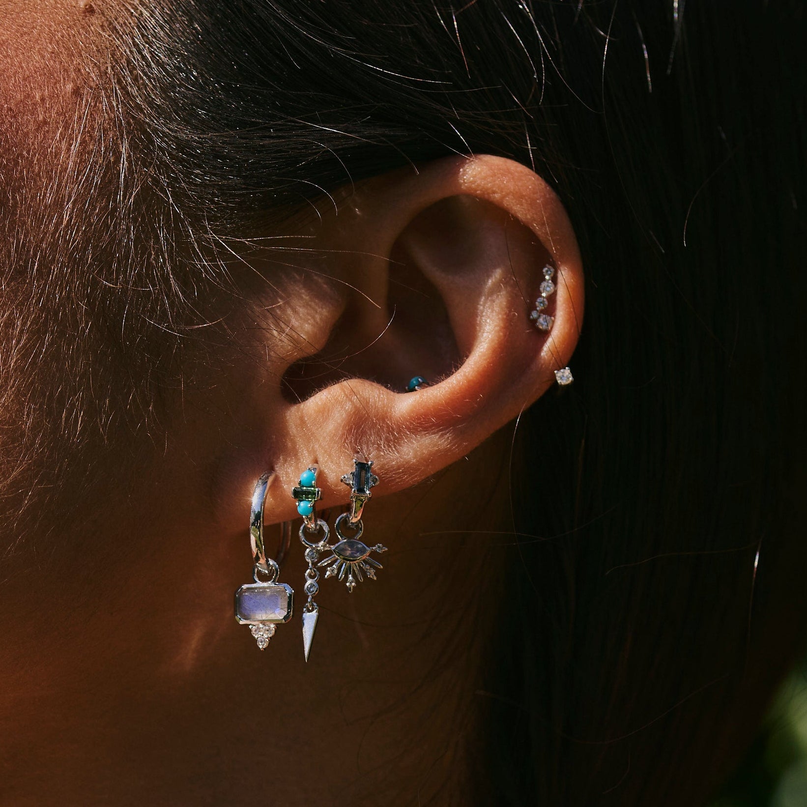 model wearing silver ear including the Green Tourmaline & Turquoise Huggie Hoop Earring Sterling Silver
