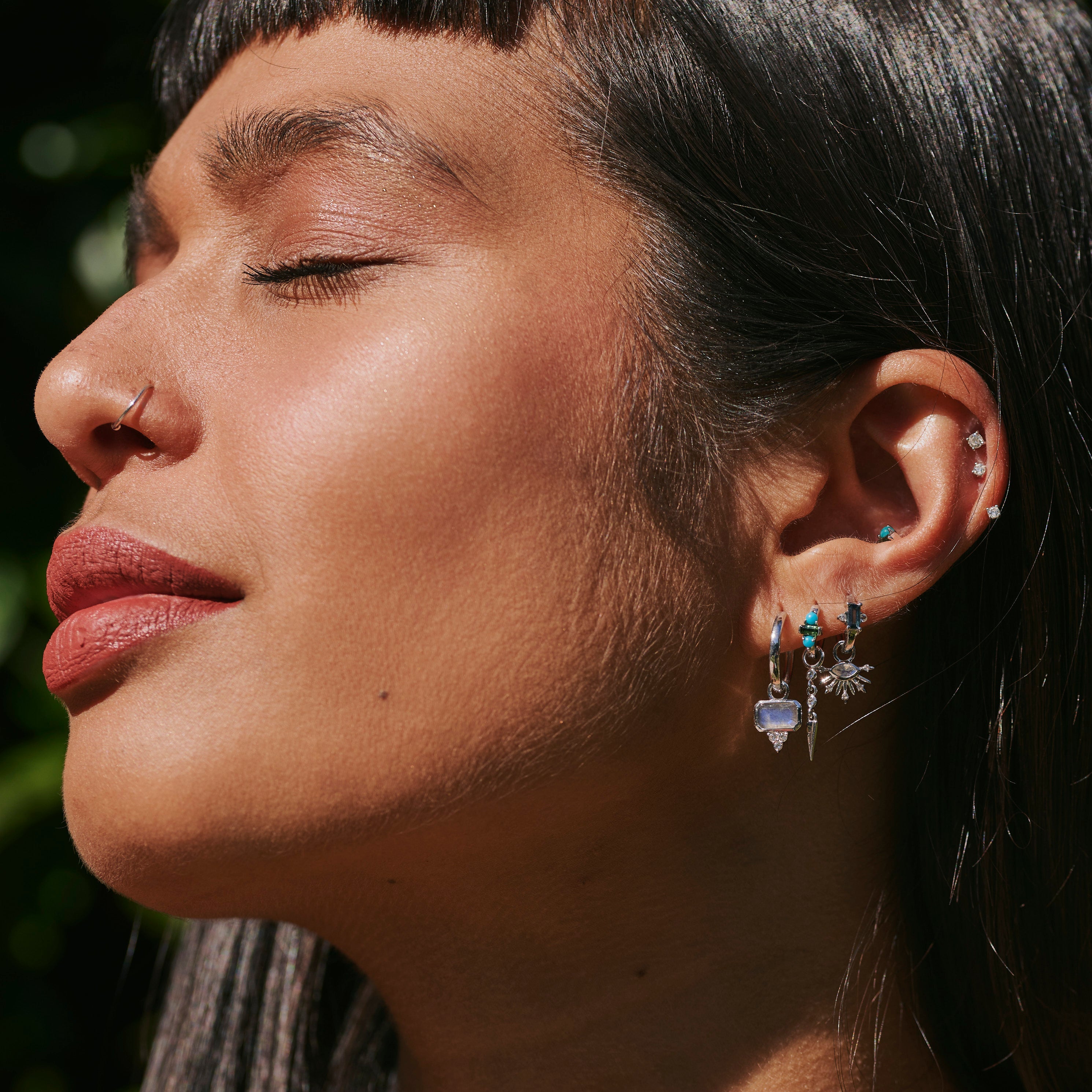 model wearing silver earrings including the Green Tourmaline & Turquoise Huggie Hoop Earring Sterling Silver