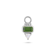 Silver charm with green gemstone and white stone on a white background
