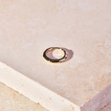 Hammered Huggie Hoop Earring 9k Gold on hard surface