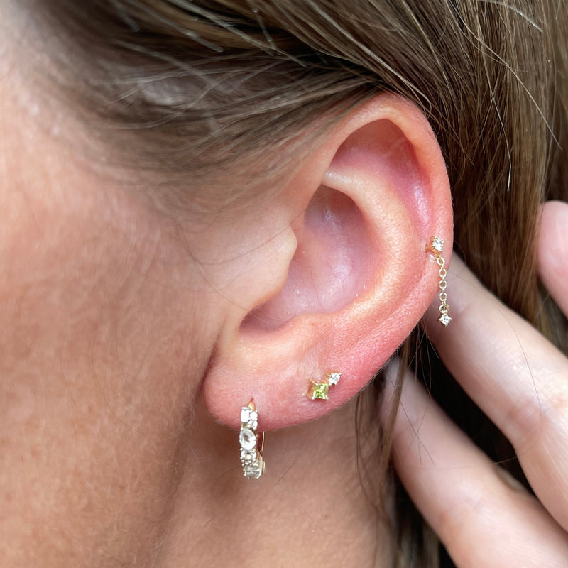 model wearing ear stack with peridot & diamond flat back earring gold on upper lobe