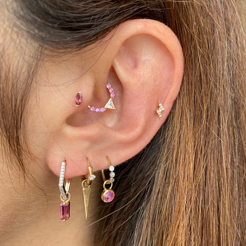 model wearing an earring stack featuring the moonstone & pink sapphire earring for daith piercings all in 9k gold
