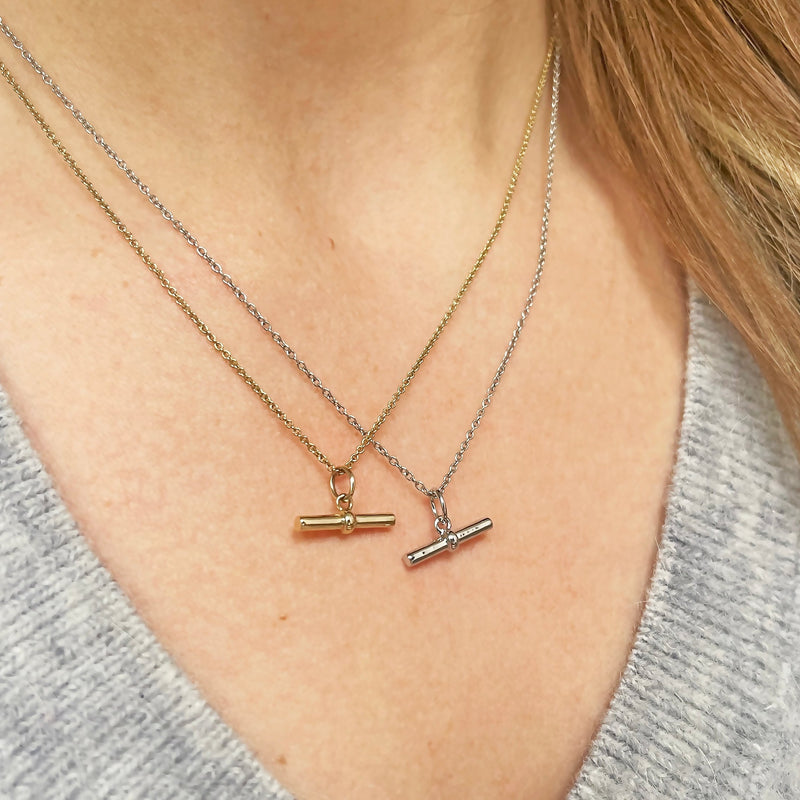 gold and silver t-bar necklaces on model