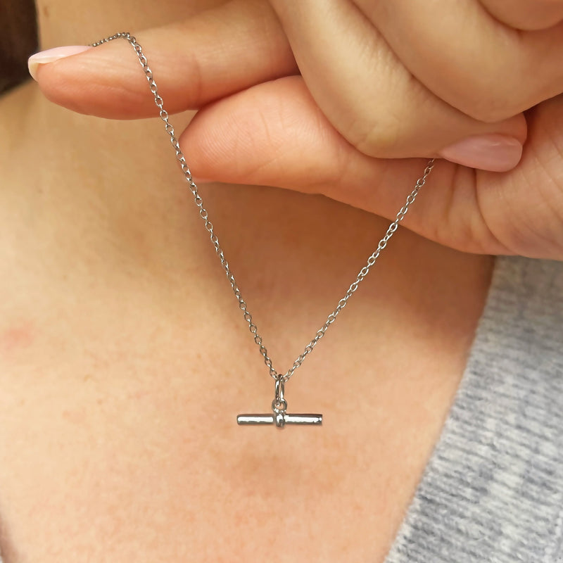 model holding a silver t-bar pendant in a cable chain 