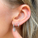 model wearing earring stack in silver including the hand of fatima amethyst earring charm