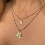 model layering the solid gold amethyst hand of fatima pendant and zohreh coin pendant