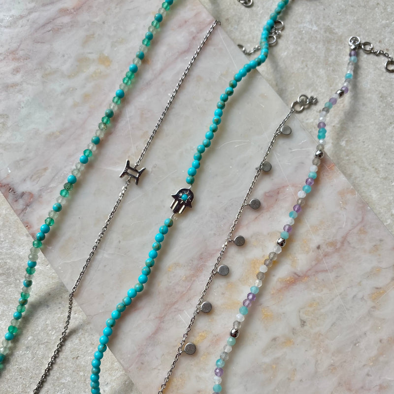 silver bracelets displayed on hard surface including the Hand of Fatima Turquoise Beaded Bracelet Sterling Silver