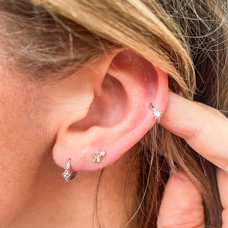 model wearing earring stack and the Peridot & Diamond Flat Back Earring 14k White Gold on second lobe piercing