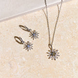 Jewelry set with star-shaped pendant on a beige surface