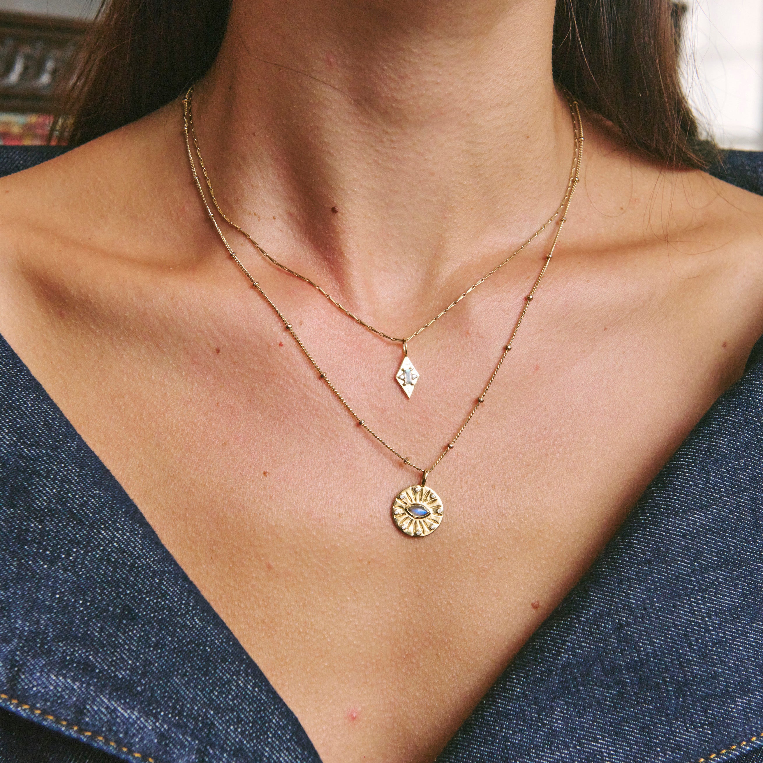 Gold necklaces on model wearing denim top
