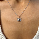 white gold necklace with a star pendant on a person wearing a white sweater.