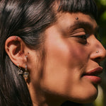 model wearing solid gold pieces including the Lotus Flower Earring Charm 9k Gold