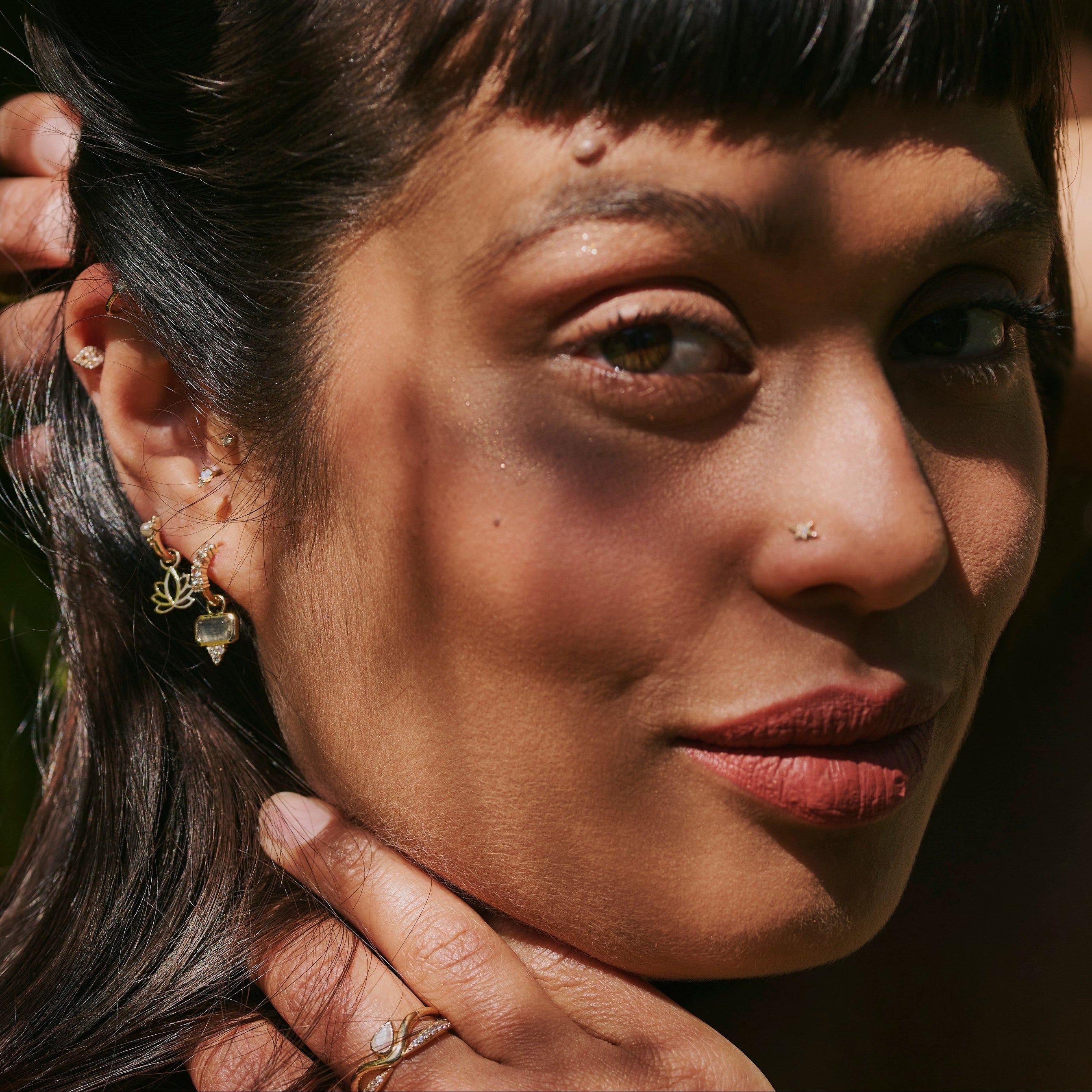 model wearing the Labradorite & White Sapphire Earring Charm 9k Gold along with other solid gold pieces