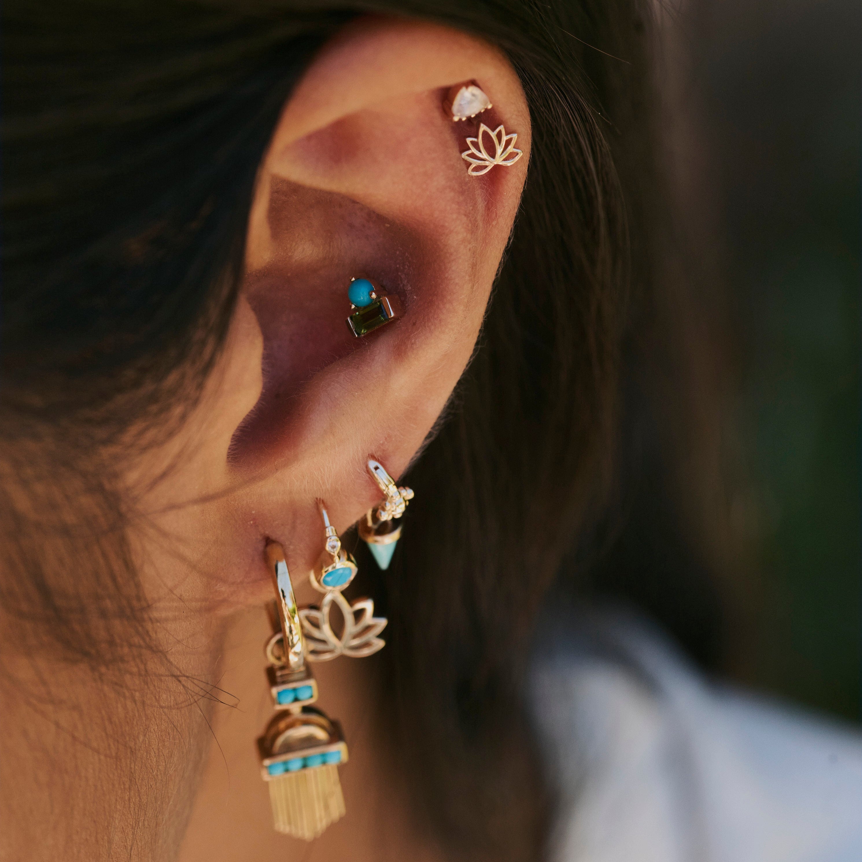 model wearing solid gold earrings including the Lotus Flower Flat Back Earring 9k Gold
