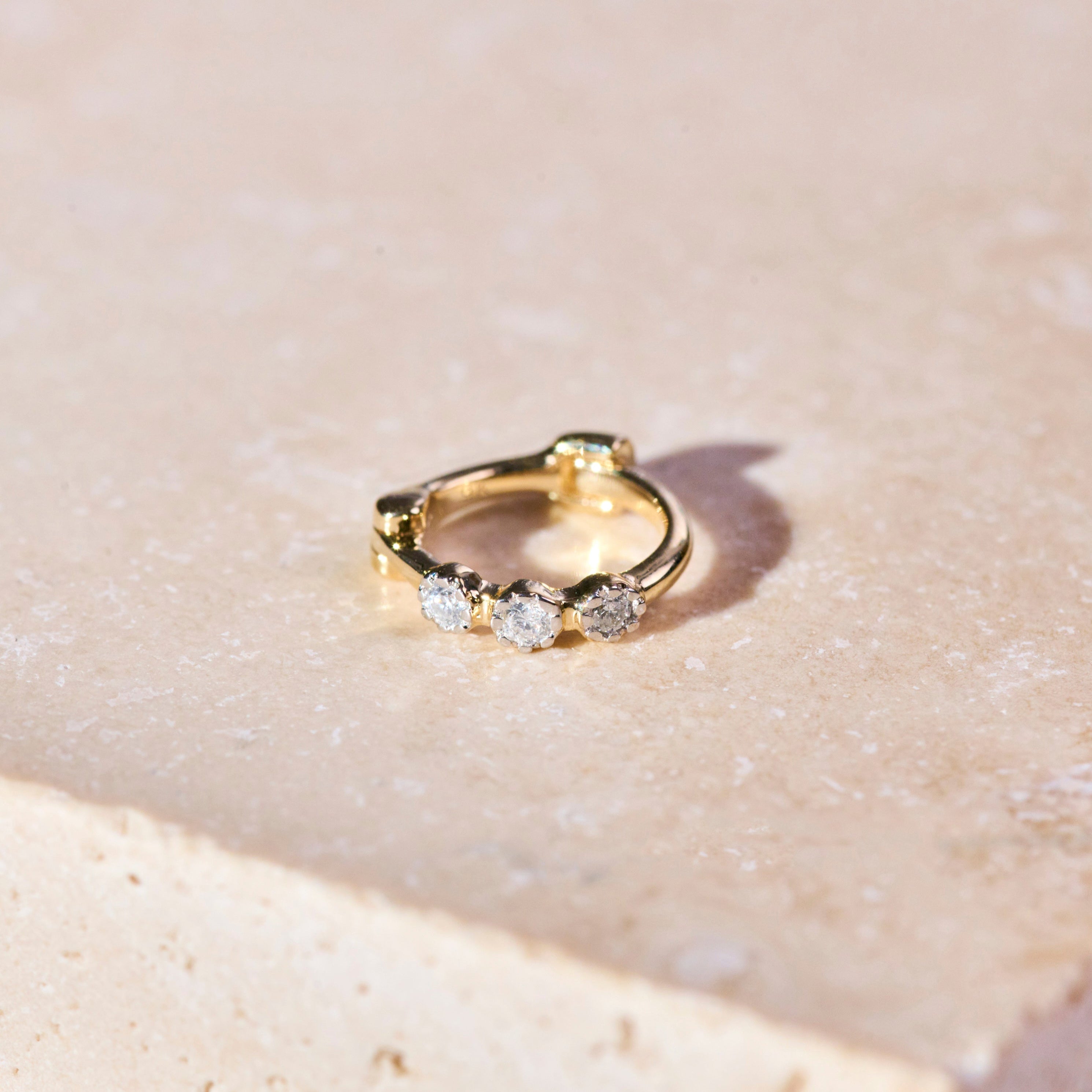 Mini Diamond Trilogy Huggie Hoop Earring 9k Gold on  hard surface