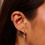 model wearing silver ear stack including the Mini Diamond Trilogy Huggie Hoop Earring Sterling Silver