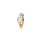Gold earring with a white gemstone on a white background