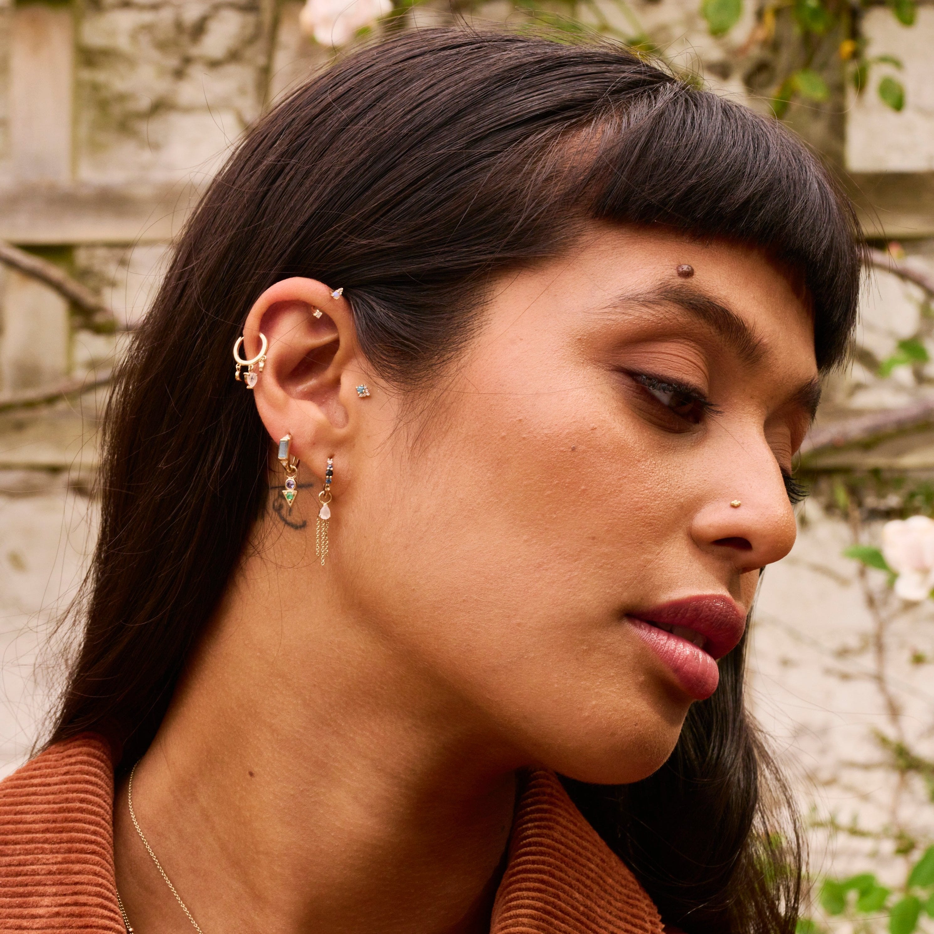 model wearing solid gold earrings including the Moonstone Celestial Huggie Hoop Earring 9k Gold