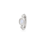 Silver huggie with a central gemstone and smaller stones on a white background