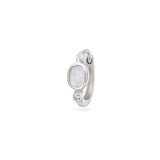Silver huggie with a central gemstone and smaller stones on a white background